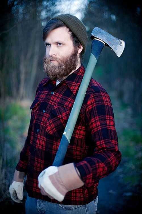 Man with full beard wearing a plaid shirt and beanie holding an axe outdoors Halloween beard costume